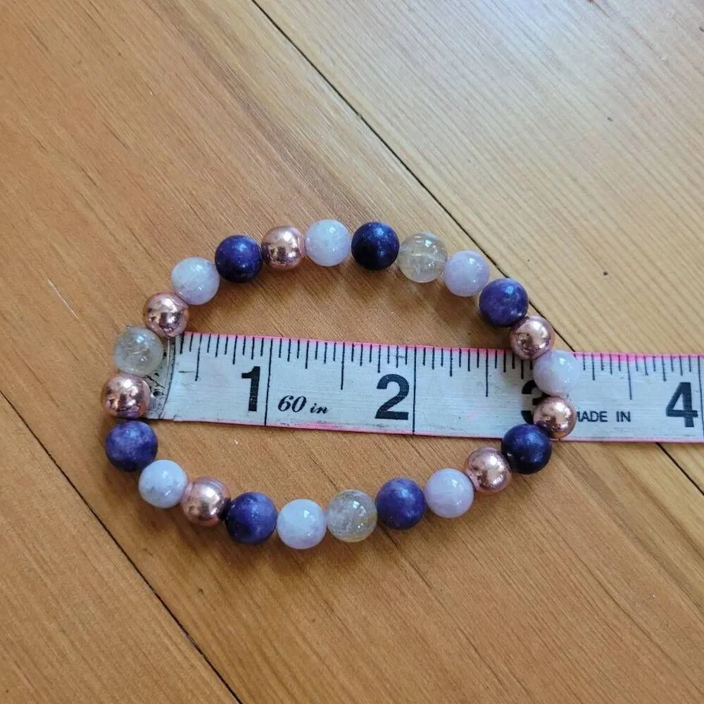 Set of two bracelets copper colored wavy bangle and stretchy beaded multicolored